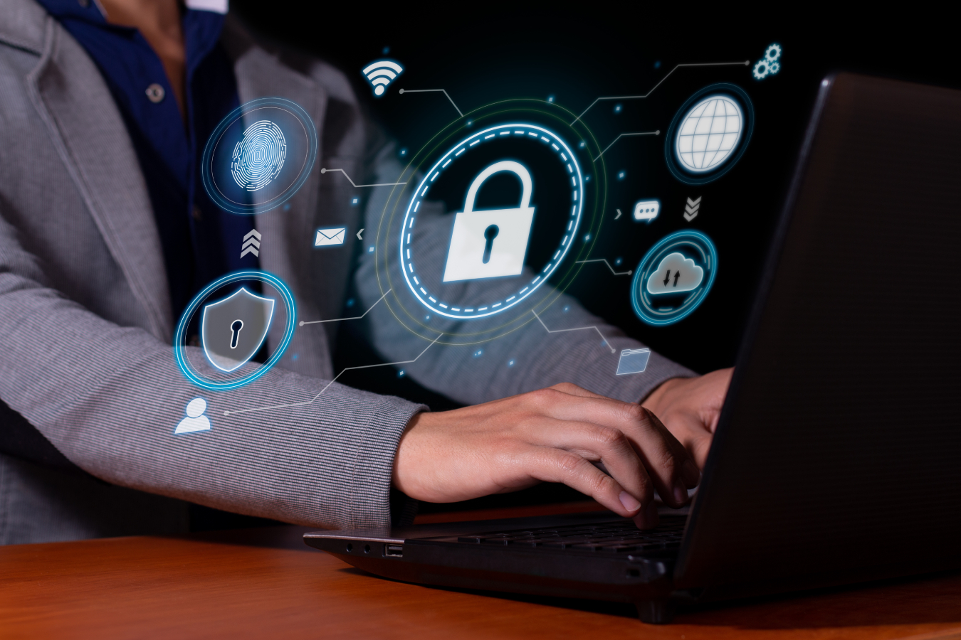 An employee using his laptop with a cybersecurity graphic in the middle.